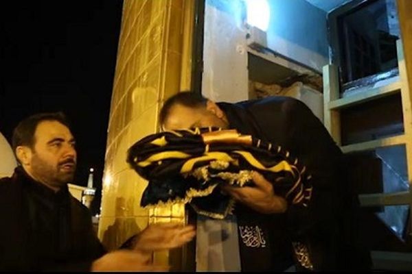 لحظه باز کردن درب گنبد حرم مطهر رضوی برای حمل و نصب پرچم عزای حسینی
